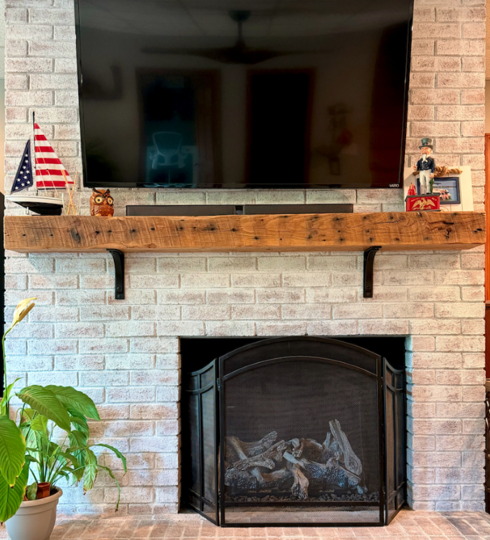 Reclaimed oak barn beam used as a fireplace mantel in a family living room
